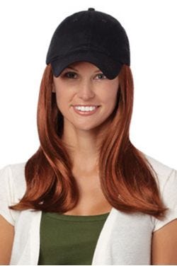 Woman in a solid black baseball cap with extra long deep auburn hair attached