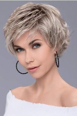 Woman in a long ash blonde lace front pixie wig with tousled hair in back