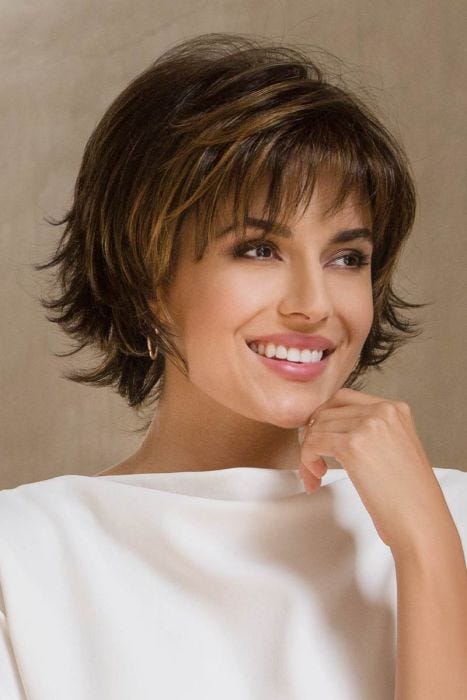 Woman in a large chin length dark brown bob with choppy layers and wispy bangs