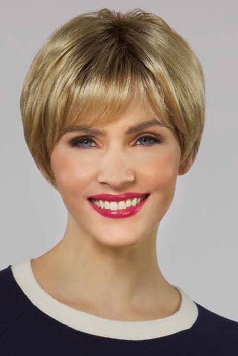 Woman in golden blonde pixie wig with longer layers in the back and wispy bangs