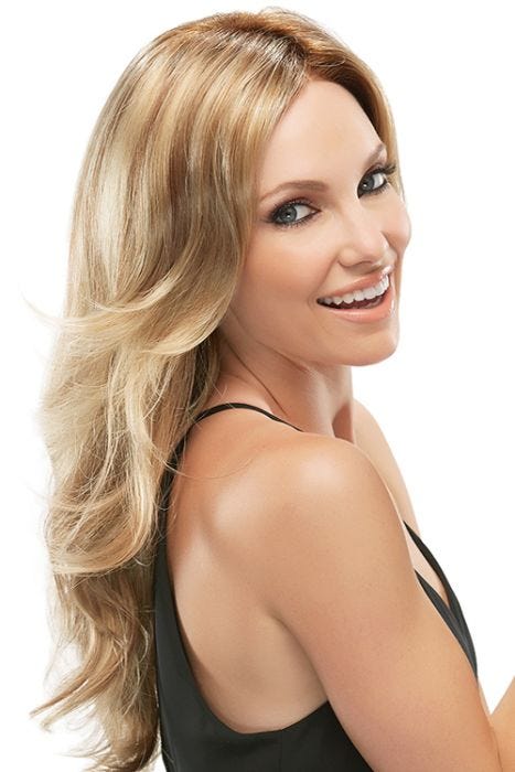 Woman in an extra long wavy reddish blonde wig with long layers at the ends and around the face