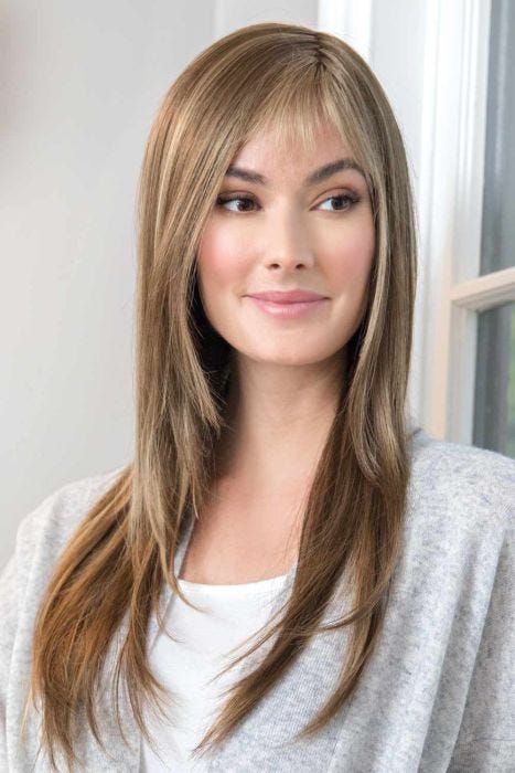 Woman in straight blonde long wig with bangs and light layers