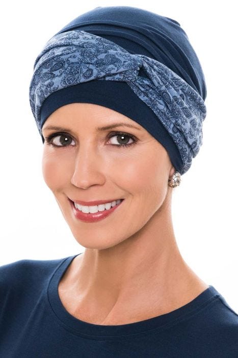 Women in navy chemo turban with blue print twist headband over the top