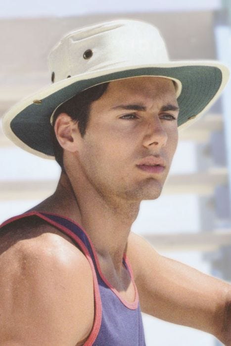 Man in white bucket style summer sun hat with chin strap