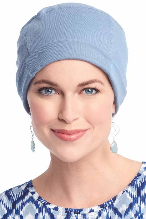 Woman in blue cotton chemo cap with cuff for women with cancer