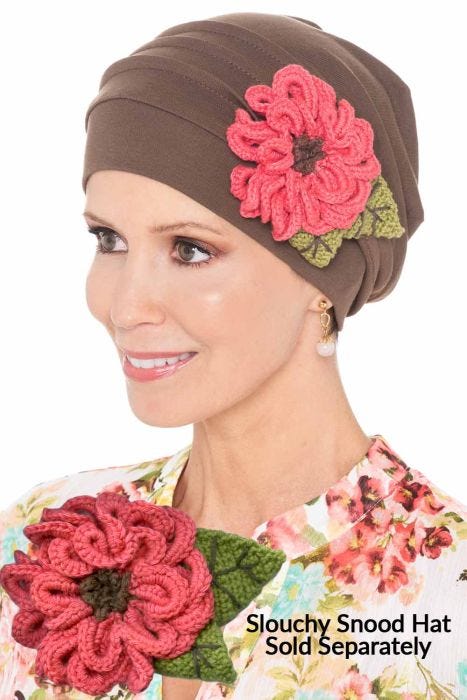 Woman in a taupe Slouchy Snood Hat with a pink aster flower pin attached