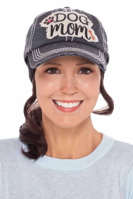 Woman in black distressed baseball cap with "Dog Mom" patch on front
