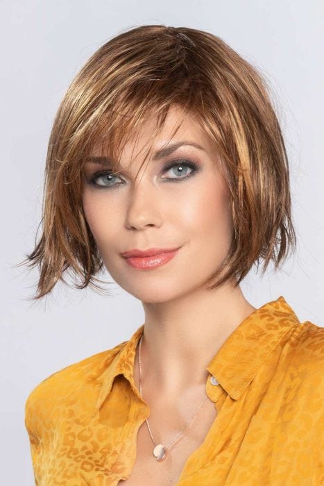 Woman in a chin length auburn rounded bob wig with side bangs