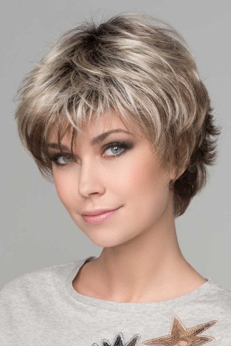 Woman in a shaggy light blonde pixie wig with longer layers on top