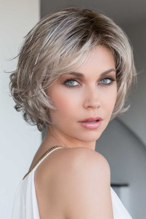 Woman in a chin length ash blonde bob wig with side bangs