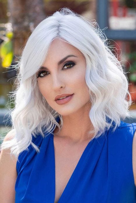 Woman in a shoulder length medium auburn curly lace front wig