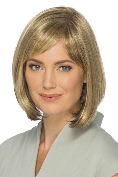 Woman in a past chin length light brown blunt bob with side curtain bangs