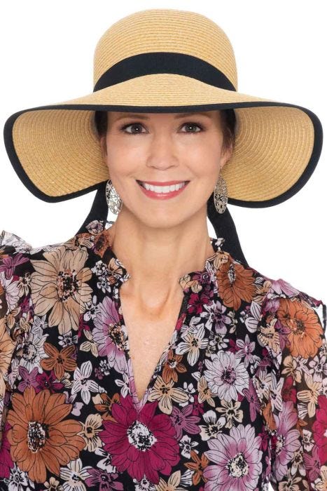 Woman in summer visor hat with big front brim, narrow back and black ribbon trim