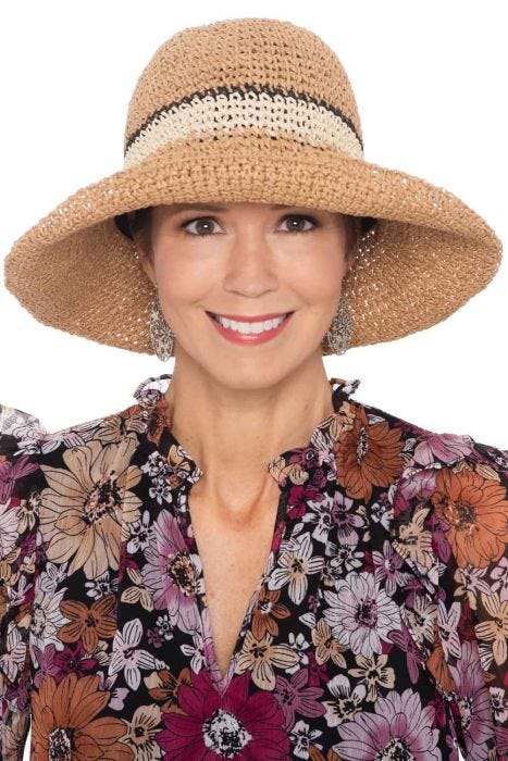 Woman in hand crocheted summer straw sun or beach hat with wire brim and two toned band for cancer patients