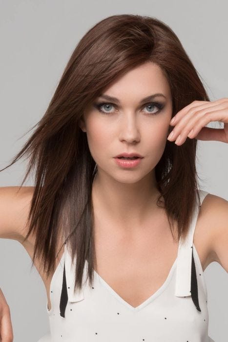 Woman in a dark brown straight past the shoulders wig with choppy layers