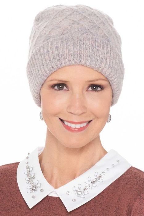 Woman in light colored cute winter beanie hat with cuff and diamond shaped stitching
