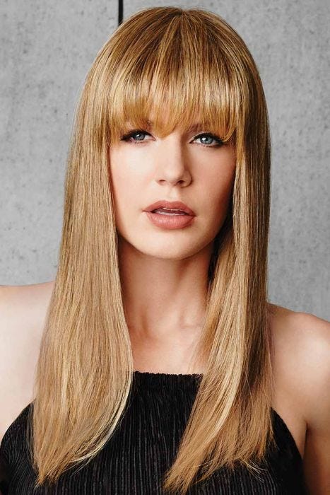Woman in a long strawberry blonde hairpiece with bangs