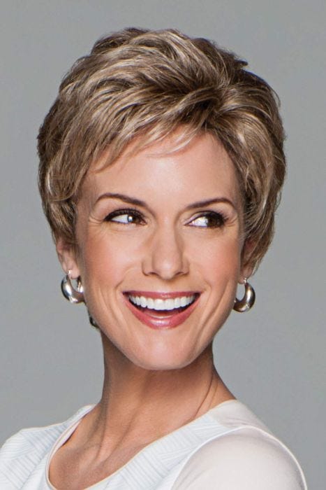 Woman in a curly dark blonde pixie wig with longer layers on the top and back
