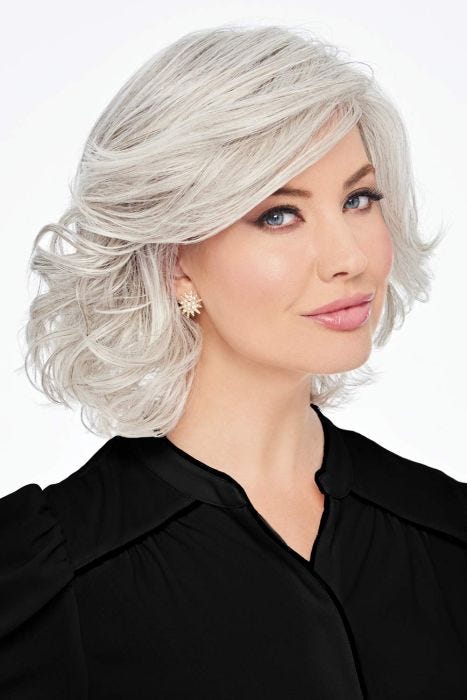 Woman in a shoulder length silver curly wig with long side bangs