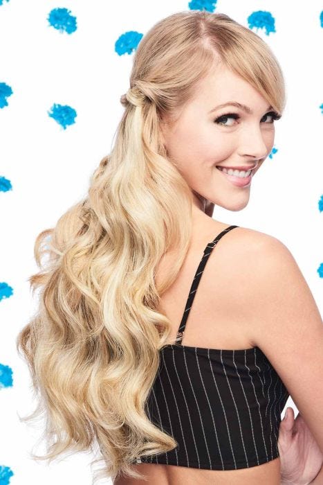 Woman in a 20" curly light blonde halo extension blended with her hair