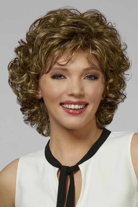 Woman in a shoulder length curly golden brown layered bob wig