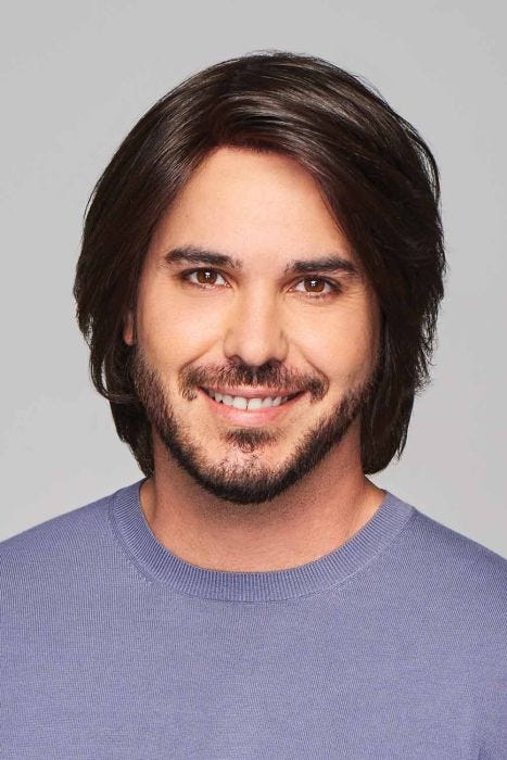 Man in a shoulder length dark brown human hair wig with shorter sides