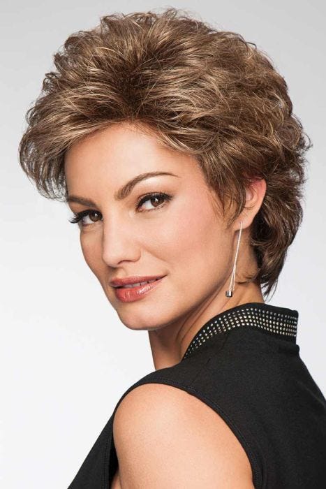 Woman in a semi-long medium brown curly pixie wig