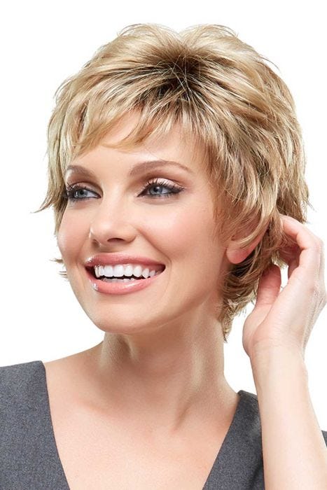 Woman in a long warm blonde pixie wig with short fringe bangs