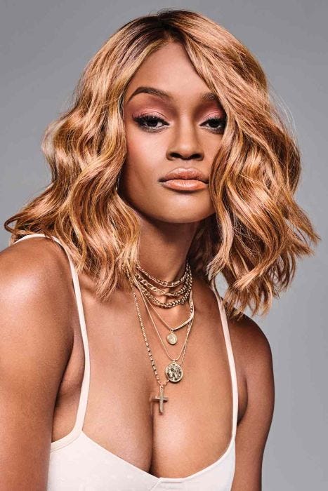 Black woman in a shoulder length wavy copper lace front wig