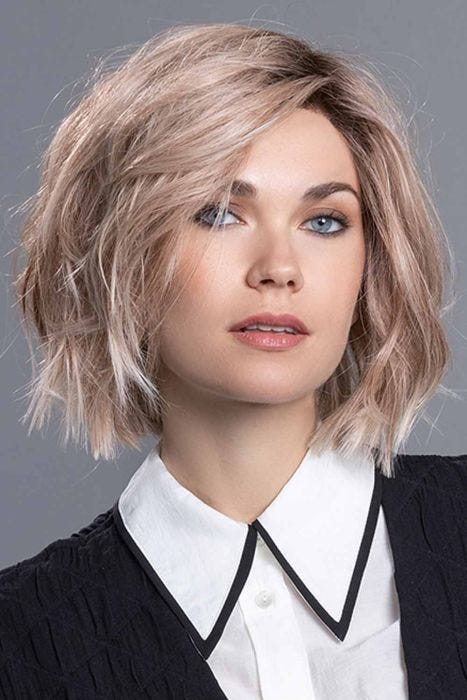 Woman in a past the chin tousled light brown razored bob wig