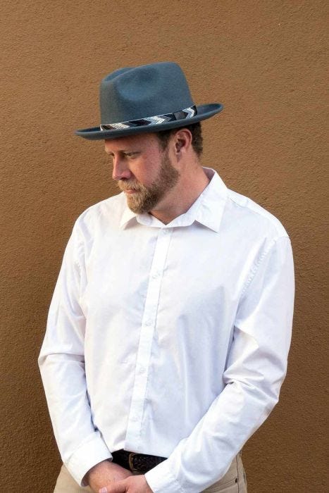 Man in grey brimmed men's fedora hat with chevron print band