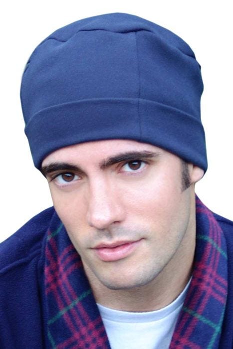 Man in soft navy organic cotton sleeping cap or night cap with adjustable cuff for balding, hair loss or chemo