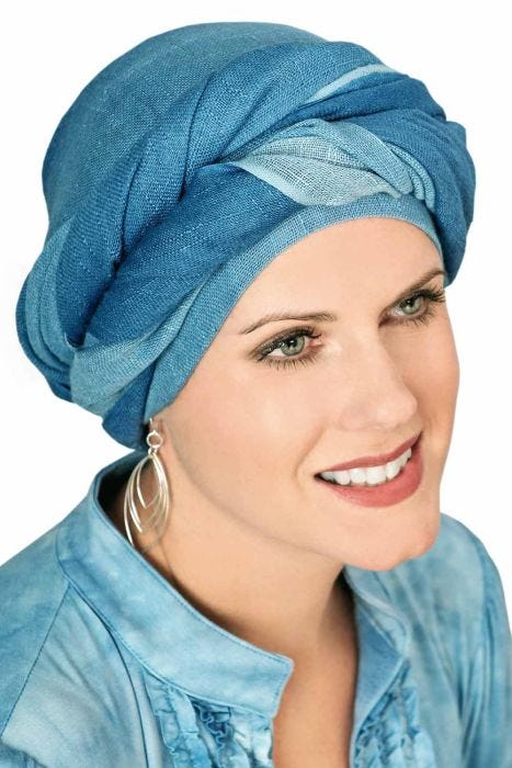 Woman in long blue head scarf wrapped into a head covering made of mesh fabric