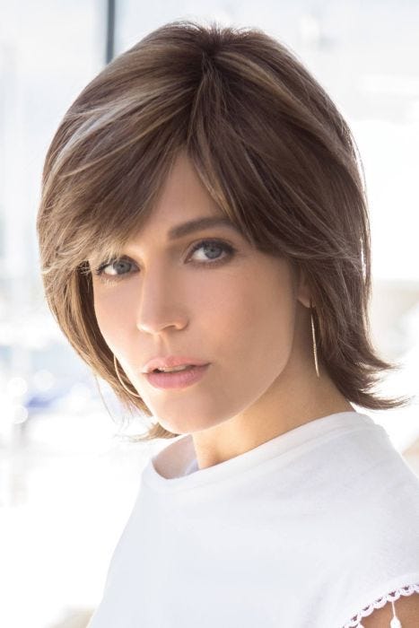 Woman in a shoulder length medium brown bob wig with side bangs and long layers