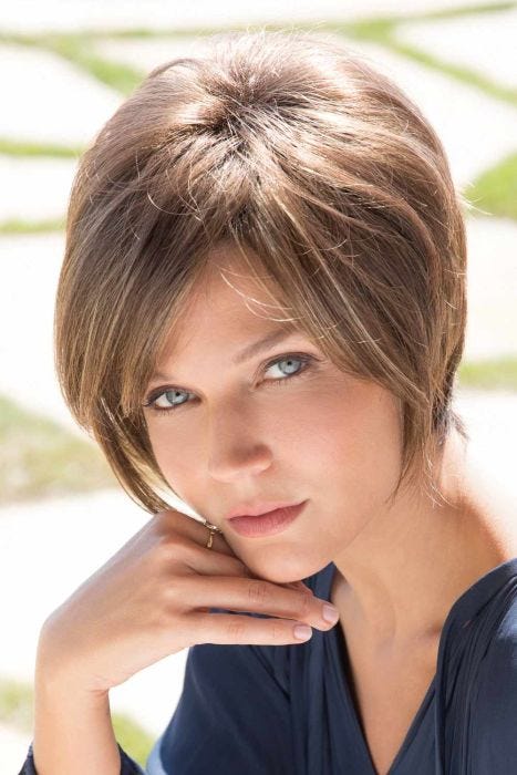 Woman in longer short brown wig with long layers to the chin