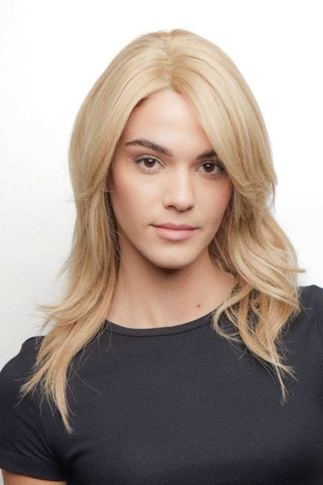 Woman in a human hair past the shoulders pale blonde with long layers and side bangs