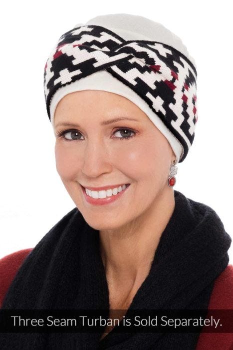 Woman in cream chemo cap with black and red aztec twist headband over the top as an accessory