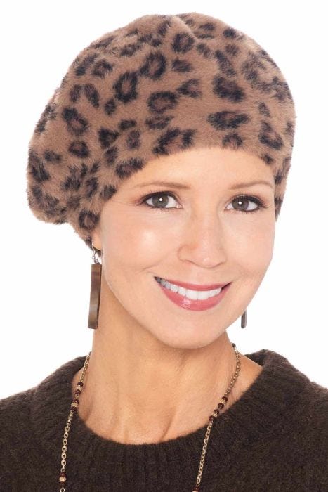 Woman in fuzzy leopard print winter beret hat