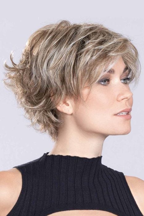 Woman in a large short shaggy asymmetric light blonde lace front bob wig with wispy bangs