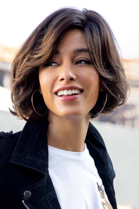 Woman in a chin length brown bob wig with long layers around the face