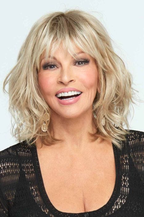 Raquel Welch in a wavy light blonde shoulder length wig with long choppy bangs