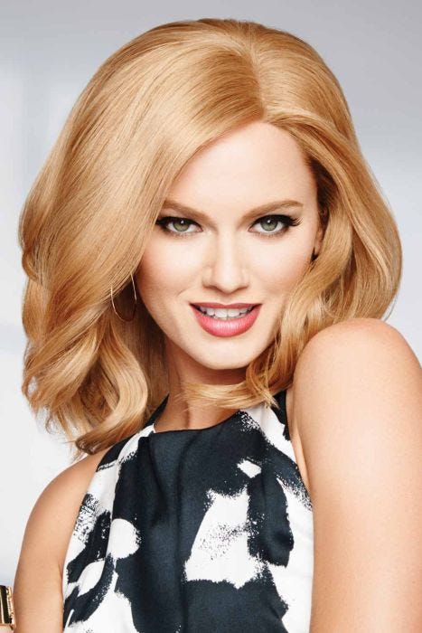Woman in a light auburn past the shoulders curly wig