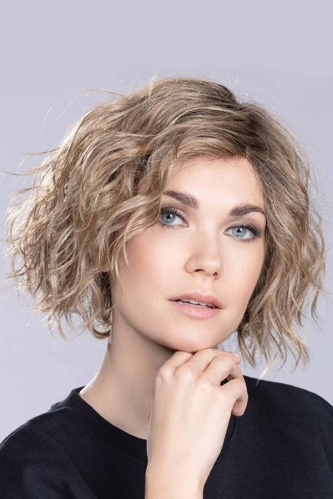 Woman in a chin length wavy light brown lace front wig