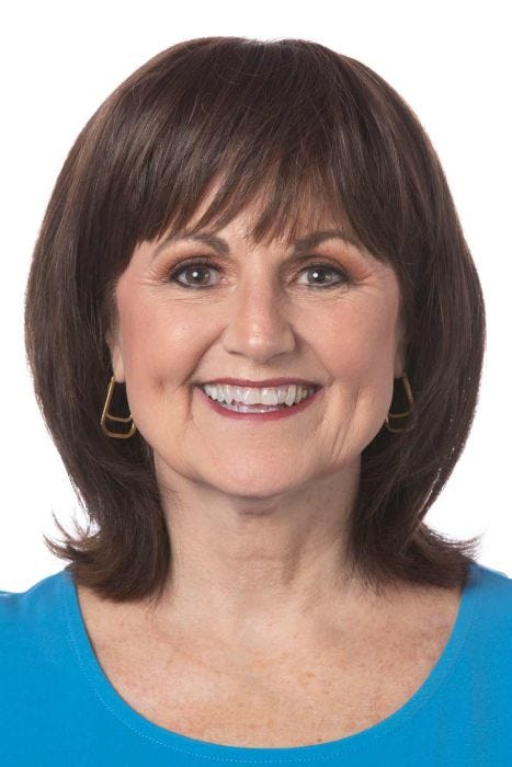 Woman in a 4.25" to 10.5" dark brown hair topper with blunt bangs