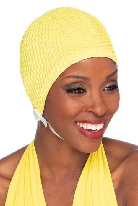 Woman in yellow textured rubber swim cap with chin strap for women