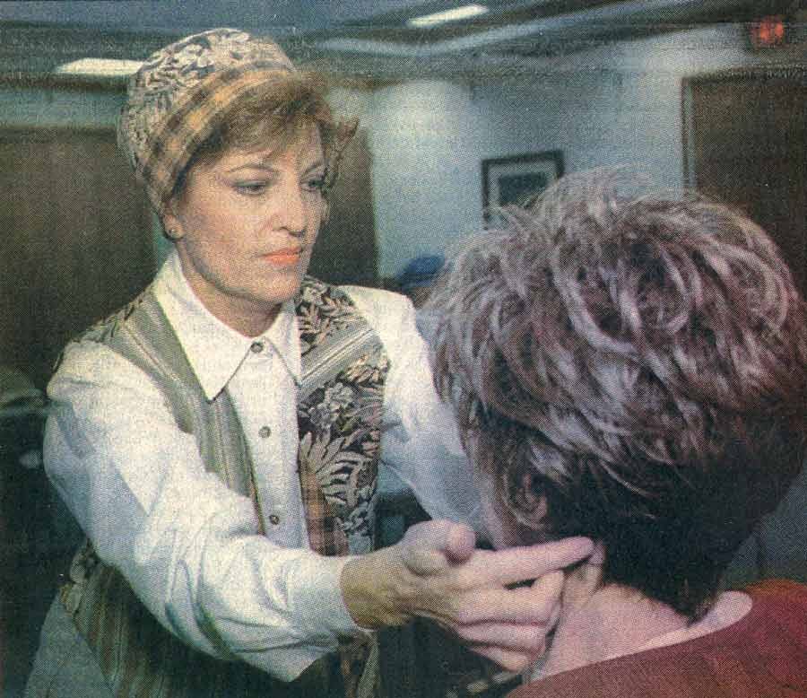 Headcovers founder wearing an original matching hat and vest combo while styling a wig for a cancer patient